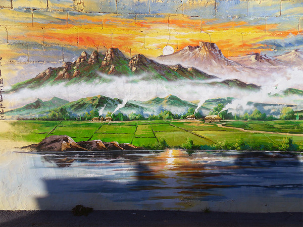 군서 모정마을 벽화의 거리에 있는 구림조연(鳩林朝煙) 그림. 모정마을 원풍정 12경 중 하나로 ‘구림마을의 아침 연기’를 그림으로 나타내고 있다.